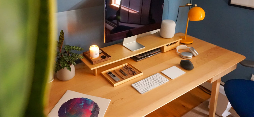 an image of a nicely organized desk with a ModWood Desk shelf in maple hardwood on it. The shelf is configured with a drawer and leg. There is also a ModWood Tray with some things organized in it.